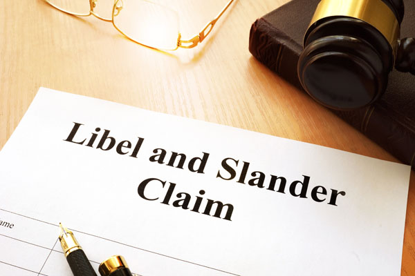Libel and Slander Claim document with gavel, book and glasses next to it